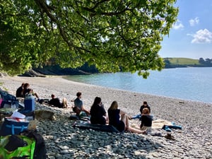 marraum team sitting on south Cornish beach looking out to sea