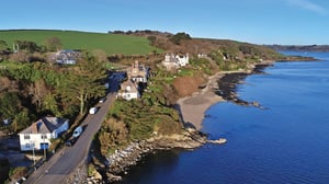 drone image of the coastline of flushing with blue skies and clear water