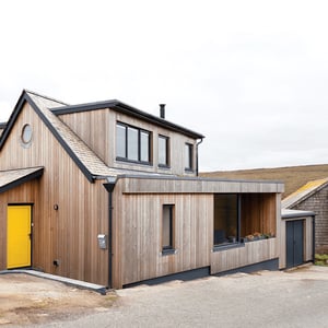 view of the front elevation of modern timber clad dormer bungalow