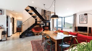 dining room with open industrial style staircase with views over the Cornish coastline