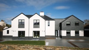 front elevation of white rendered house with slate hung extension