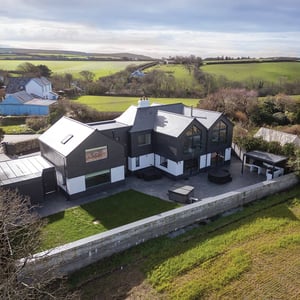 rear external view of three gabled building and surrounding fields