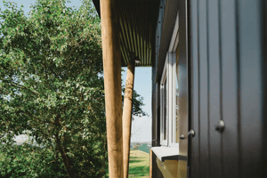 close up view of wooden supports on exterior of metal clad building