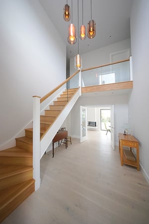 entrance hall with large hanging light pendent and kited wooden staircase