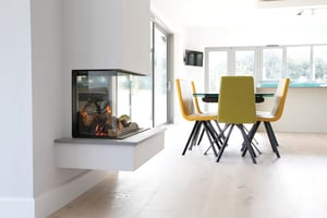 glass fronted wood burner with dining table behind