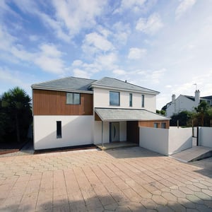 rear entrance of white painted home with covered door and grey windows