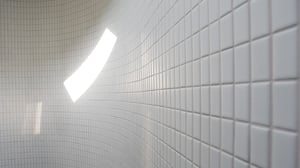 white bathroom tiles with a patch of sunlight reflecting
