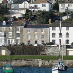 stone terrace house with eight white windows seen from out in the harbour