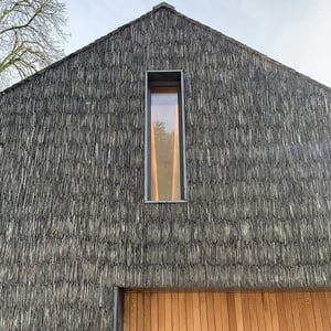 a striking image of the gable end of a new boat house, with featured slate finish