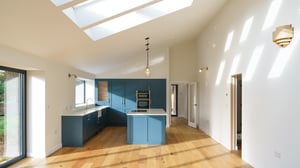 Open plan kitchen with lots of natural light flooding over a natural timber floor