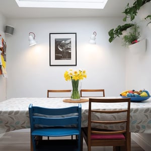 dining room table with vase of yellow daffodils in the centre