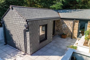 slate hung extension to a stone outhouse