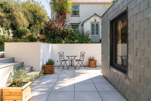 view of two patio chairs and a table with farmhouse behind