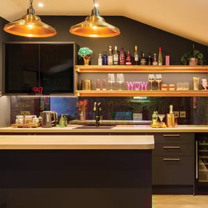 view of bar with glossy black units and glasses on display
