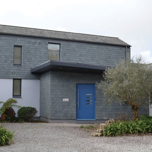 home with blue front door and slate hung walls
