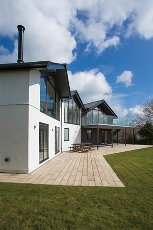 new build home with three angled gables and paving in front