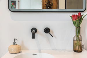 wall mounted black sink taps with tulips in vase