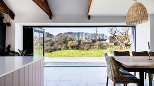 internal view from kitchen out of large bifold doors towards garden and surrounding tree line