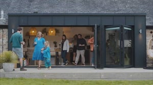 Image of friends and family walking out of large bifold door