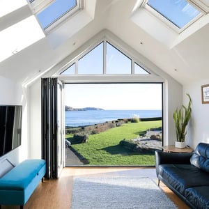 internal view looking out of open bifold doors towards the surrounding water