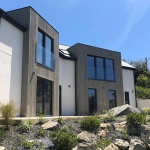 new building with two large bays clad in grey timber composite material