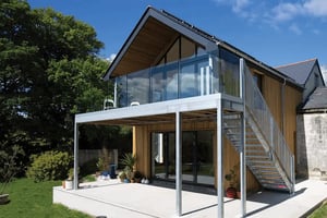 timber clad extension with industrial metal balcony