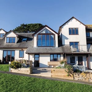 view of the outside with large dormer windows and blue sky